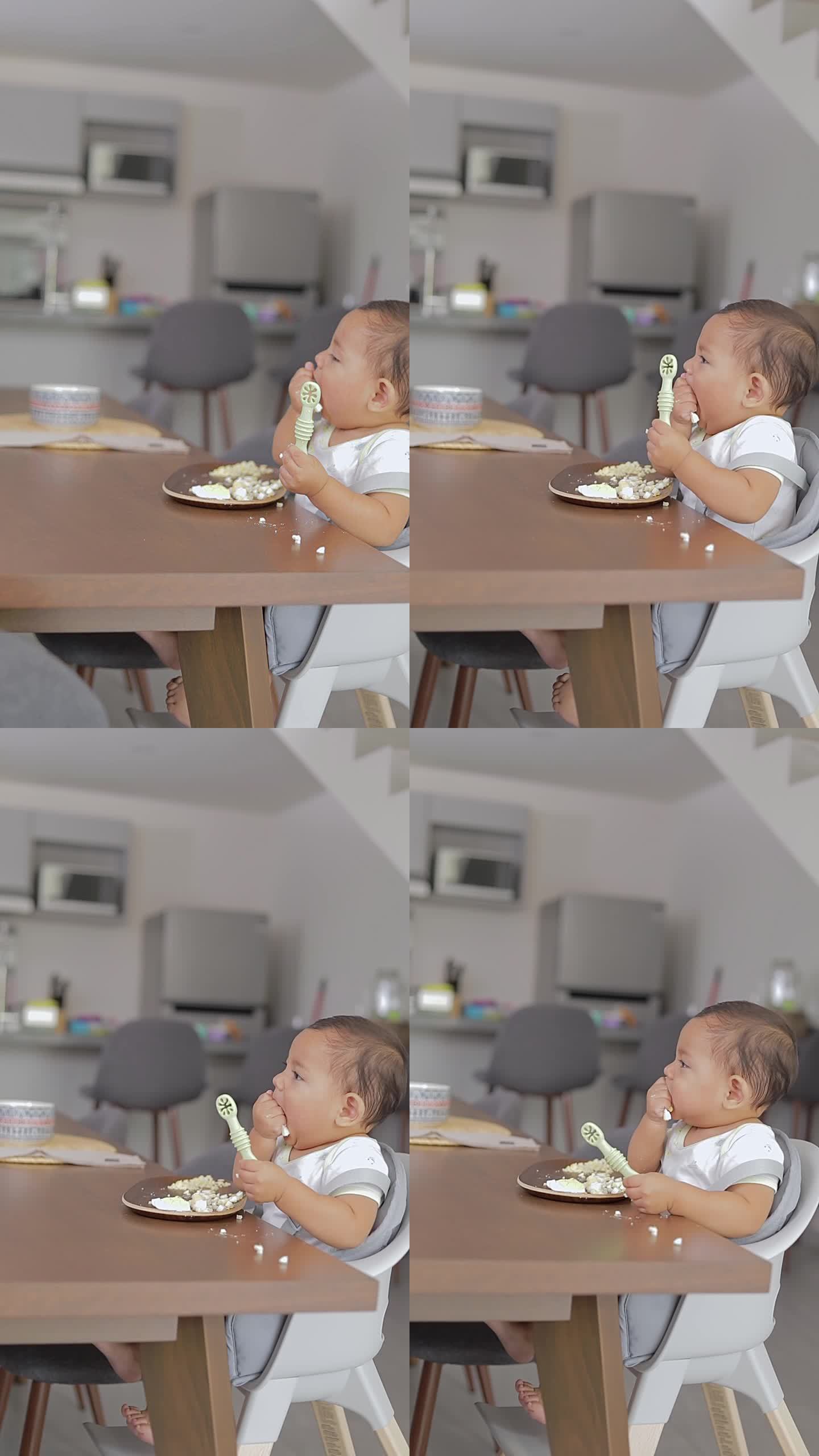 婴儿坐在桌子旁，用手拿着勺子吃东西。