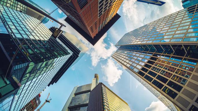 商业企业现代建筑摩天楼低视角延时平移，在市中心高层建筑中反射多云天空