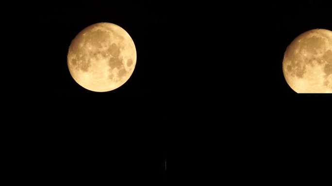 从地球上透过大气层看到的金色满月，映衬着繁星点点的夜空。一轮巨大的满月划过天空，月亮从左下角移动到右