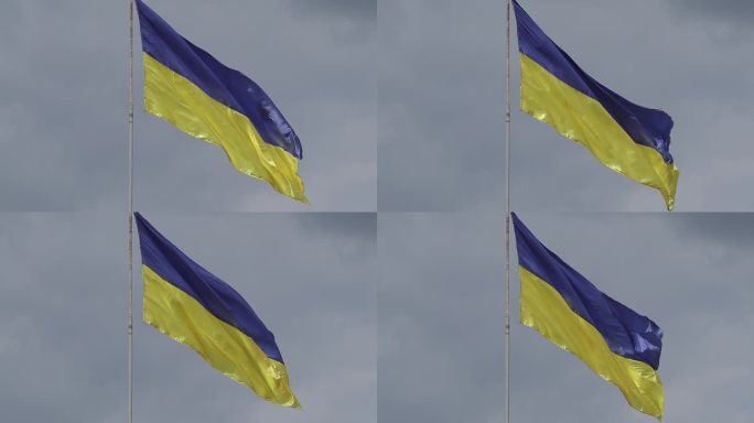 一面破损的乌克兰国旗在多云的天空中飘扬。