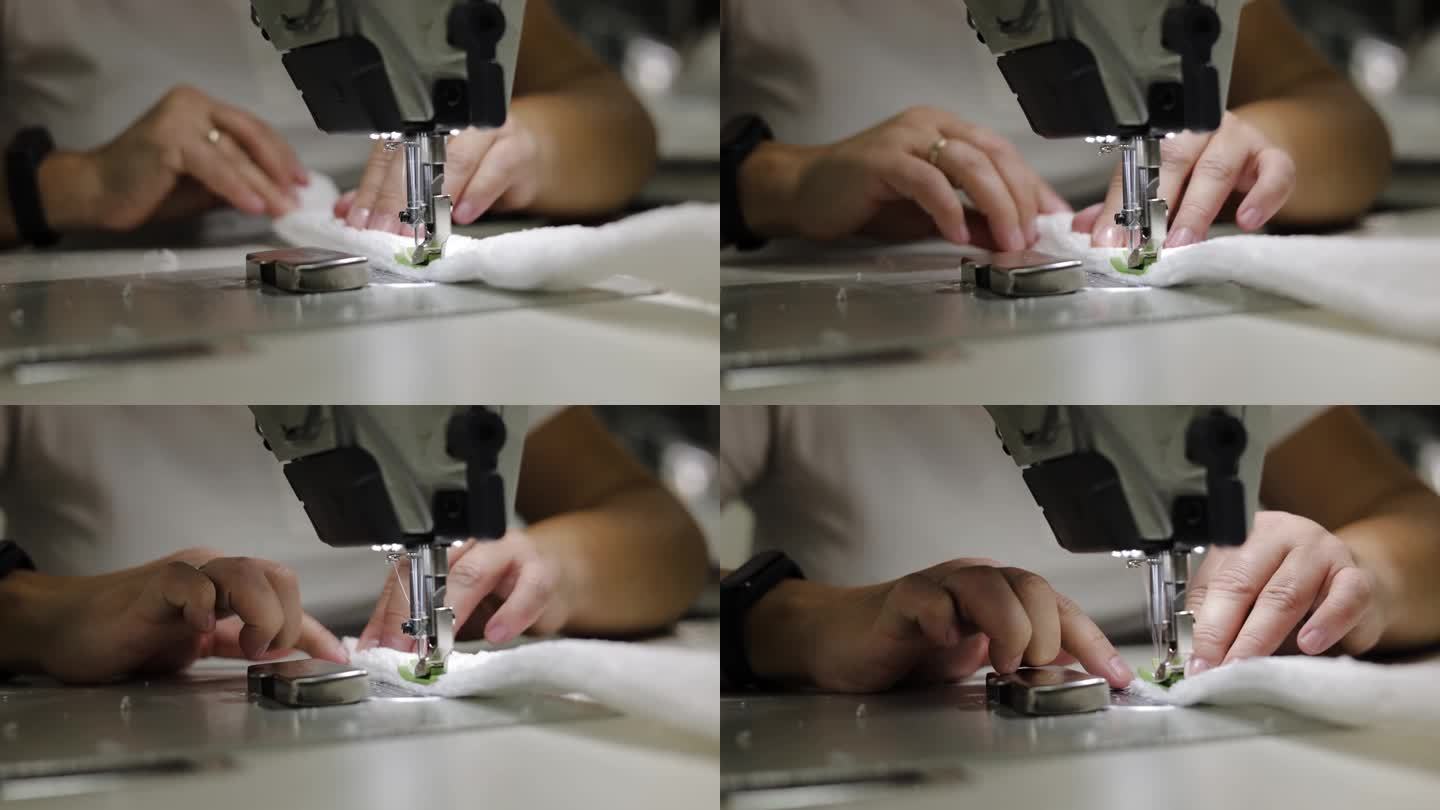 一个不知名的人用专业的缝纫机用针在白色布料上缝缝。时尚设计师坐在办公桌前缝制蓬松的面料。