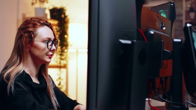 女黑客正在看一台多显示器的超级计算机
