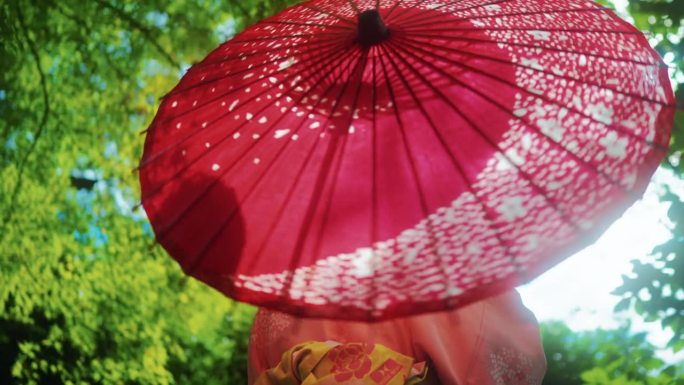 穿着日本和服的美女手持红色雨伞在森林风景中呼吸