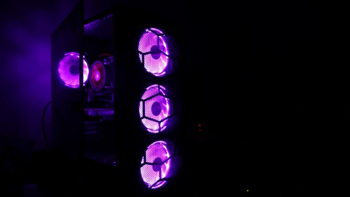 暗室游戏电脑系统单元中的霓虹灯多色冷却器。冰球迷。旋转冷却器，现代电脑。文字复制空间，专业
