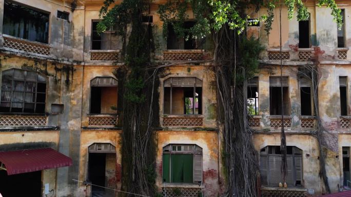 无人驾驶飞机拍摄的“幽灵”建筑在废墟中，在法国保护期间，柬埔寨金边的旧警察局-摄像机向前移动到建筑物