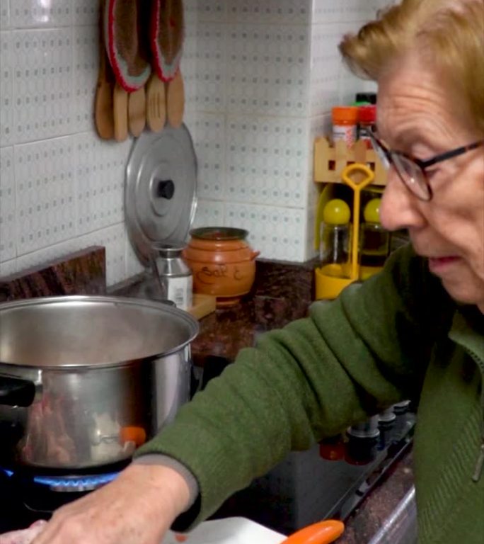 大龄妇女用炖锅煮鸡的家庭生活