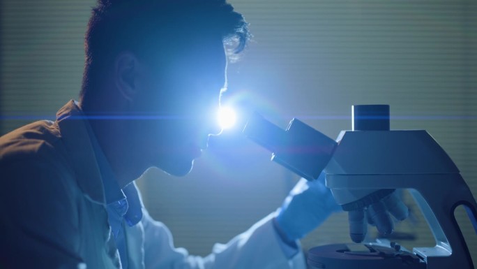 科学，人类和研究在实验室用显微镜检查颗粒，微生物或DNA测试。微生物学，科学家和研究用紫外线进行数据
