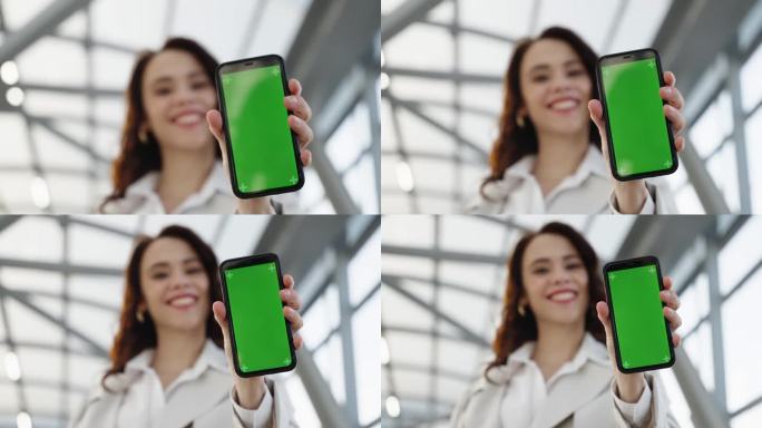 在女孩拿着的移动设备的屏幕上，你可以看到一个绿色的背景，可以代替。