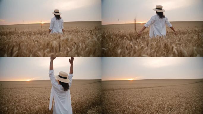 一名妇女在广阔的麦田里举起双臂欣赏日落的后景