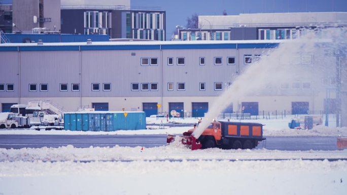 铲雪车清理国际机场航站楼和跑道上的冰