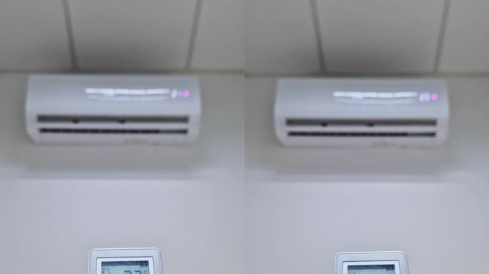 特写:男子手持遥控器，按下空调系统的按钮，试图将房间的温度调节到舒适的水平。凉爽季节的家庭供暖