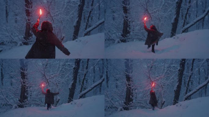 年轻女子穿着暖和的斗篷，戴着兜帽，手持燃烧的火炬在雪堆中奔跑