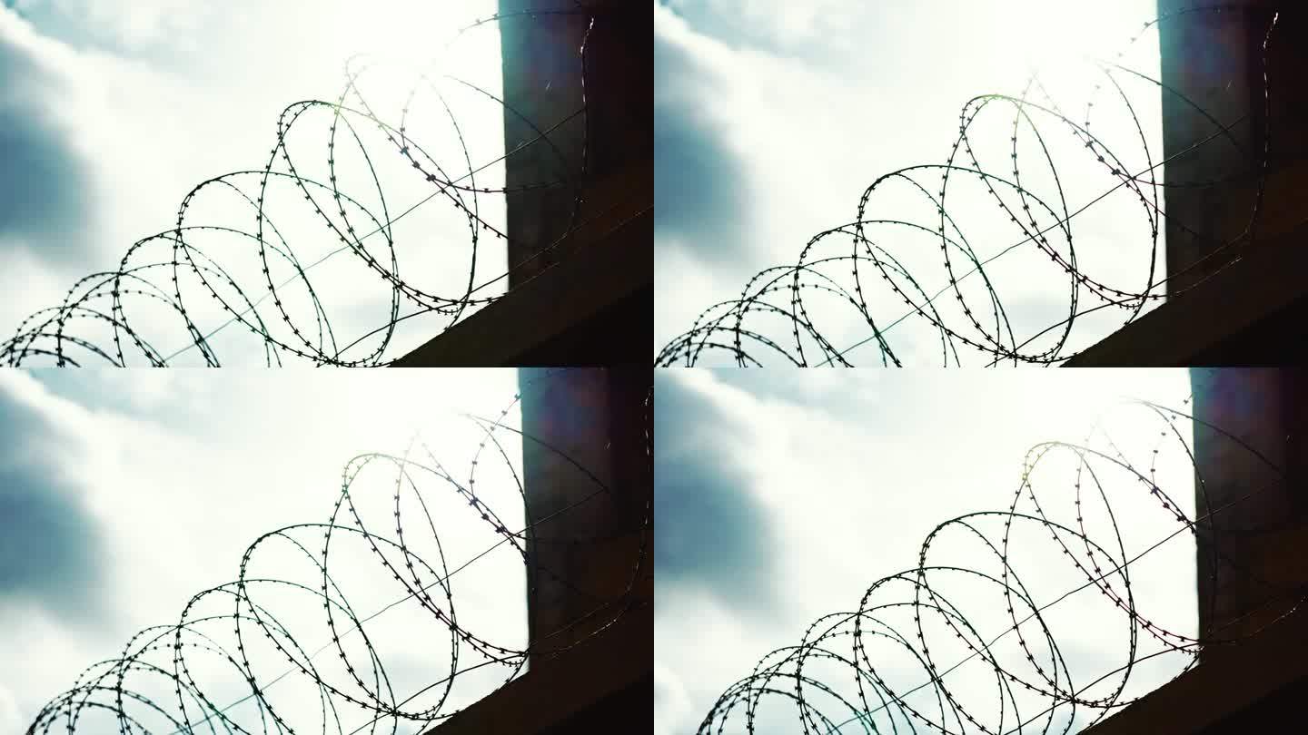 在监狱和教养所发现的监狱铁丝网。对着天空的有刺铁丝的栅栏。特写镜头。安全系统禁区。锋利的剃刀在手风琴