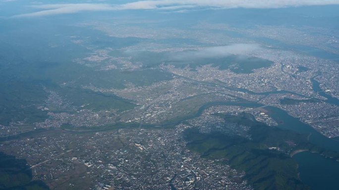 从飞机上鸟瞰日本上空的自然日出天空、绿色景观山和白云