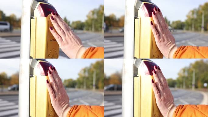 波兰女子用手按黄色按钮打开人行横道上的交通灯
