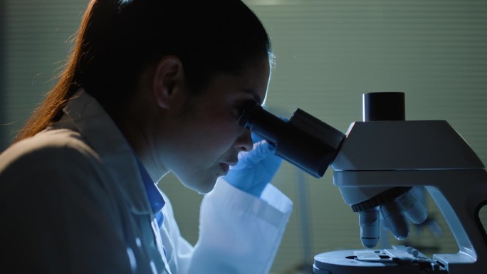科学，妇女和学生研究用显微镜研究粒子，微生物或DNA测试。微生物学，科学家和实验室的数据分析，样本调