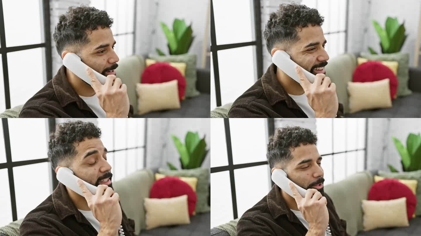 一个留着胡子的年轻人在一个舒适、现代的家里用固定电话交谈，让人产生一种随意交流的感觉。