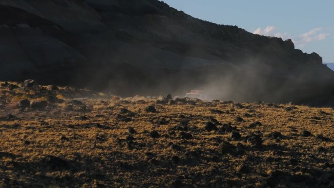 白色的汽车开过了山，在晴朗的日子消失在尘土飞扬的沙漠景观中