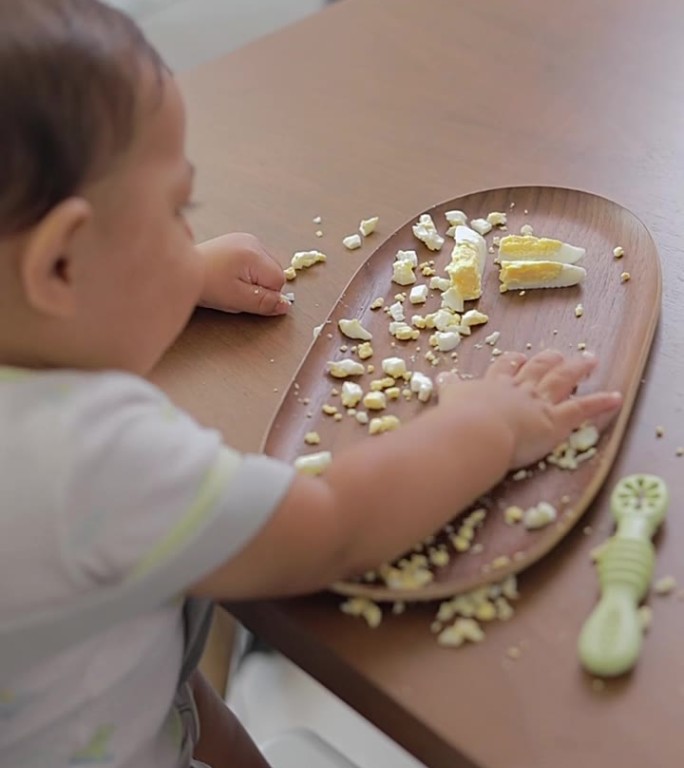 宝宝在家吃早餐时测试食物的质地。婴儿主导的断奶概念