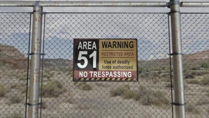 高质量的3D CGI渲染，在沙漠场景中一个秘密军事设施的铁链围栏上，有一个51区警告禁区的标志。