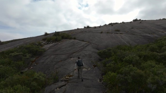 在摄像机飞过去拍摄峰顶之前攀登陡峭的花岗岩表面。