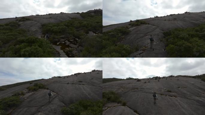 在摄像机飞过去拍摄峰顶之前攀登陡峭的花岗岩表面。