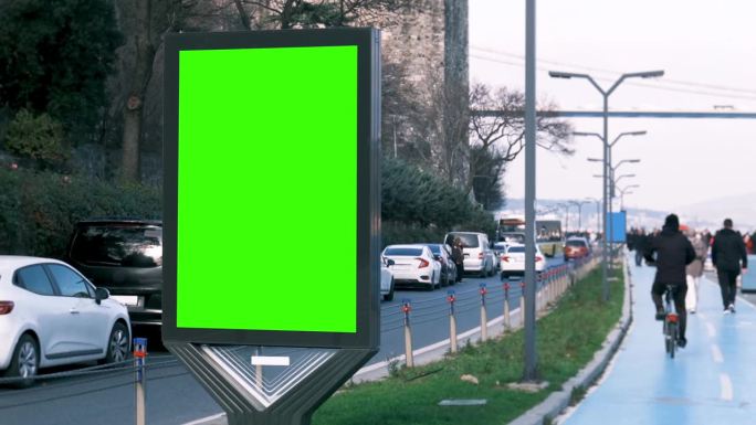 4K绿幕广告牌和人们沿着海滨小路行走。