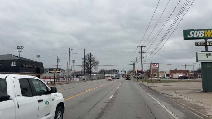 汽车视图拍摄行驶在圣奥尔本斯的主要道路，WV过去的地方和特许经营企业在一个阴天