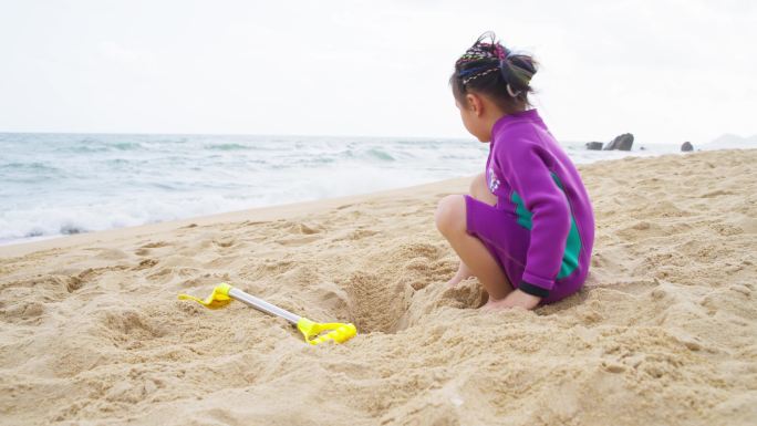 可爱小女孩在海滩玩沙子