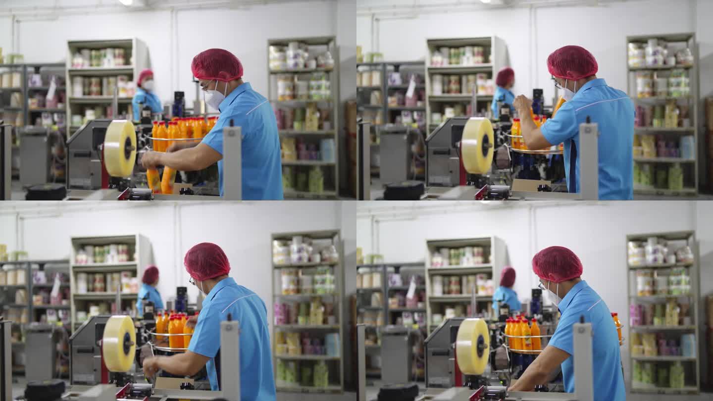 亚洲华人生产线工人在包装前拿起并检查橙汁瓶