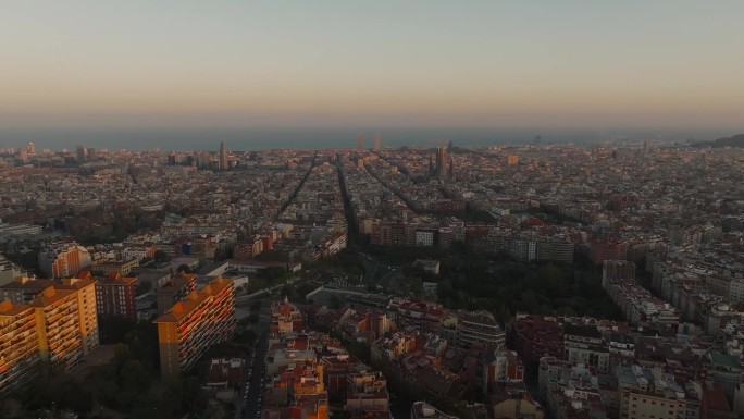 鸟瞰巴塞罗那城市天际线和日落时的圣家大教堂。