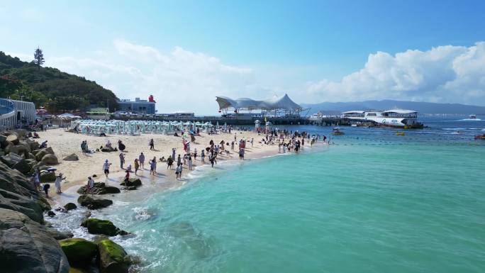 航拍海南三亚玻璃海白沙滩上旅游度假的游客
