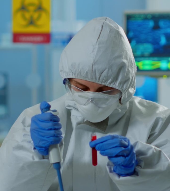 垂直视频:穿着防护服的科学技术人员使用微移管和培养皿分析血液样本