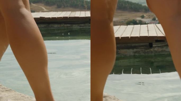 垂直视频。从下面看一个女人的腿，她走在白色悬崖的顶端。Pamukkale的石灰华。