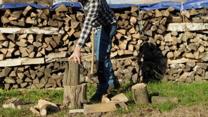 伐木工人在为冬天砍柴，年轻人拿着斧头砍柴，慢镜头准备好了