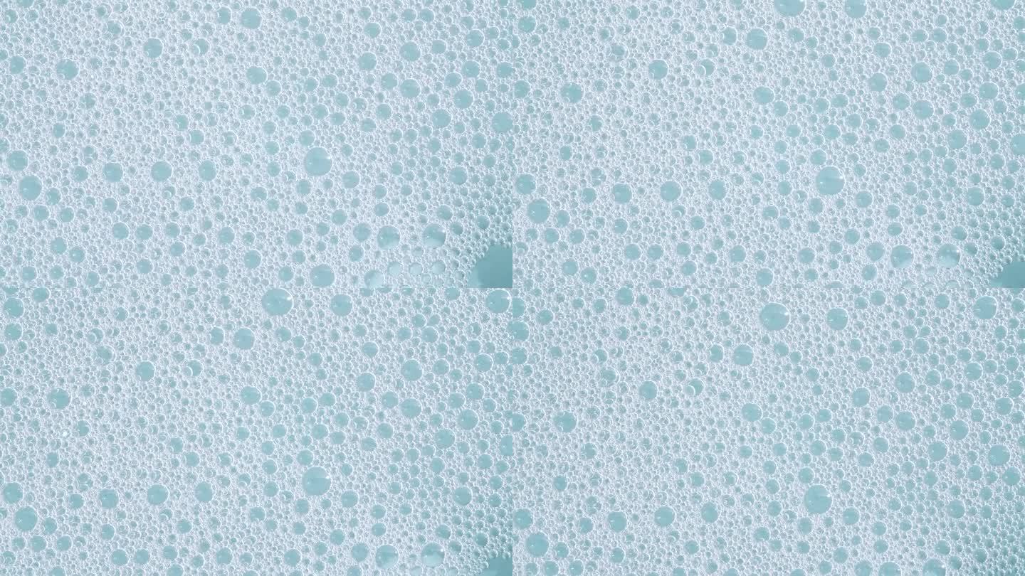 肥皂泡沫在蓝色背景下移动。天然白色洗发水泡沫运动。沐浴皂泡沫。肥皂泡的质地。
