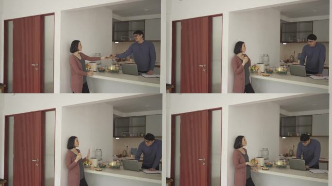 亚洲孕妇和丈夫周末在厨房柜台享受茶歇