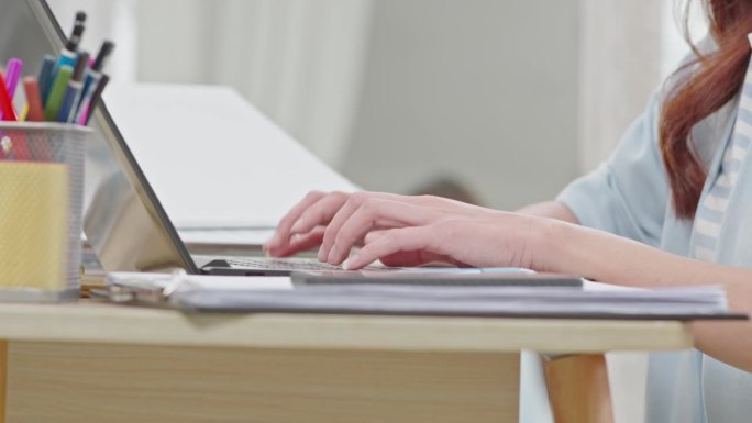 商务女性在电脑键盘上打字的近距离手。女人的手在家里的工作台上聊天或写文章。B卷打字到电脑通讯