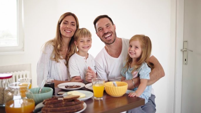 快乐的年轻家庭在家里一起吃早餐