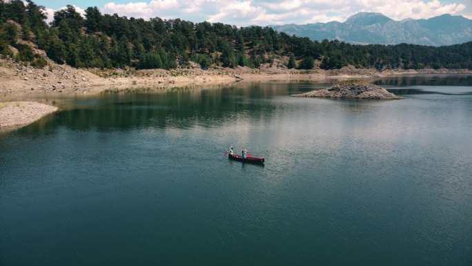 鸟瞰图，妇女和孩子在湖上与养鱼场划独木舟