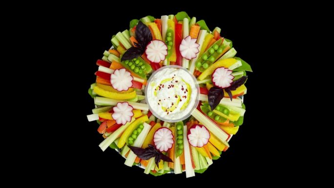 切成片的生蔬菜放在盘子里，配上白酱。五彩缤纷的节日餐桌装饰，自助餐。前视图。视频是循环与alpha通
