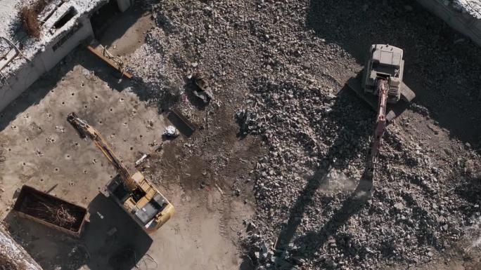挖掘机在拆迁现场清理垃圾。无人机拍摄的被毁建筑物的画面。
