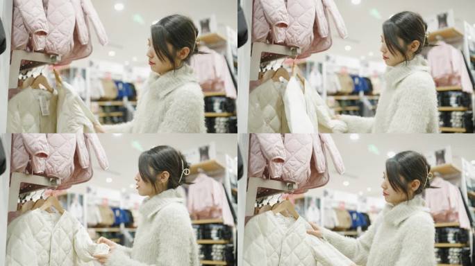 年轻的亚洲妇女在商场挑选童装