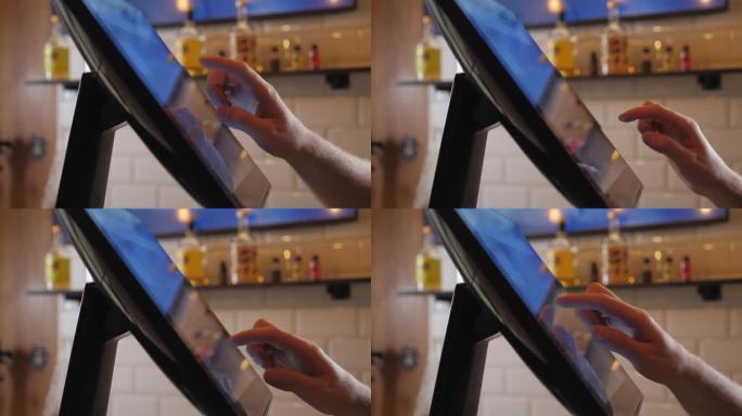 服务员在咖啡馆工作，用触摸屏为顾客下单。