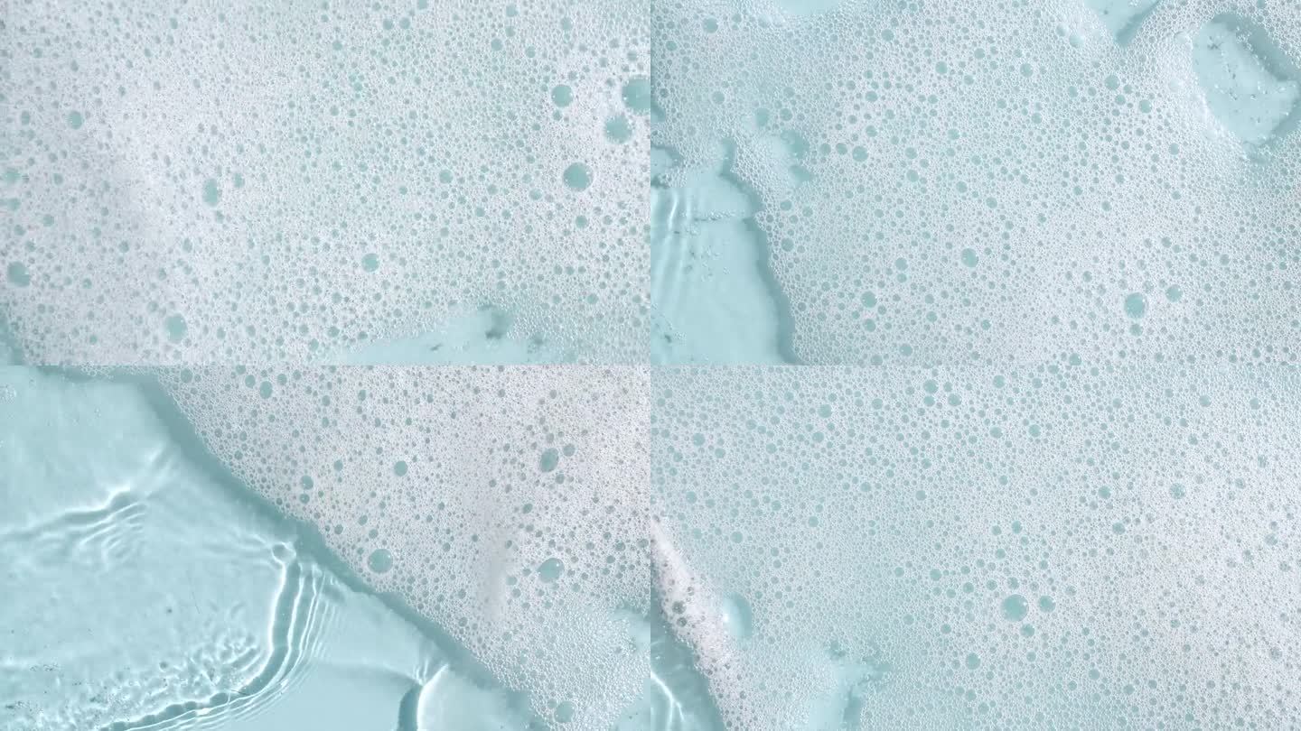 白色的肥皂泡在蓝色的背景上。沐浴皂泡沫。肥皂泡的质地。天然白色洗发水泡沫运动