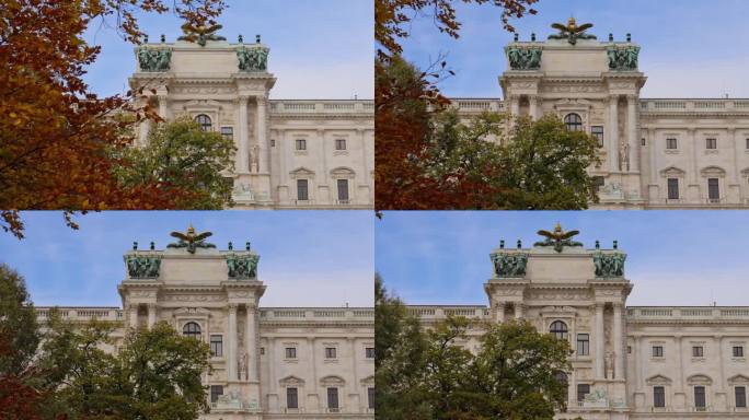 奥地利维也纳，霍夫堡宫的一部分——新堡宫的外立面，被一棵色彩斑斓的秋树上的叶子所揭示