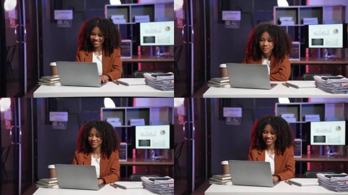 非洲女企业家查文件发邮件，职业商人上网冲浪，以彩灯为背景，按期加班的概念