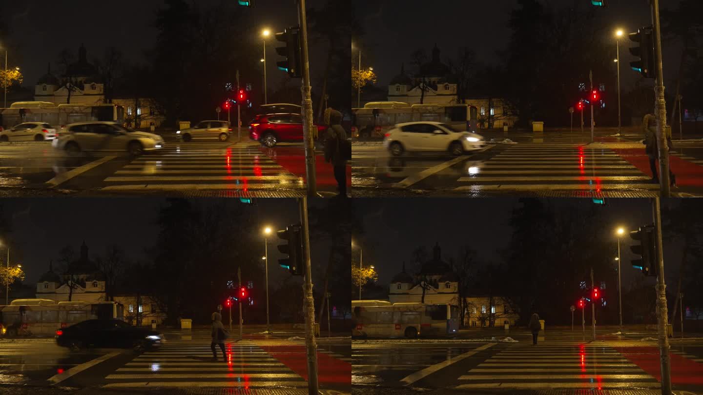 妇女在马路上非法穿过斑马线，在下雪的夜晚，汽车亮绿灯，行人亮红灯。人行横道在恶劣天气下威胁交通安全。