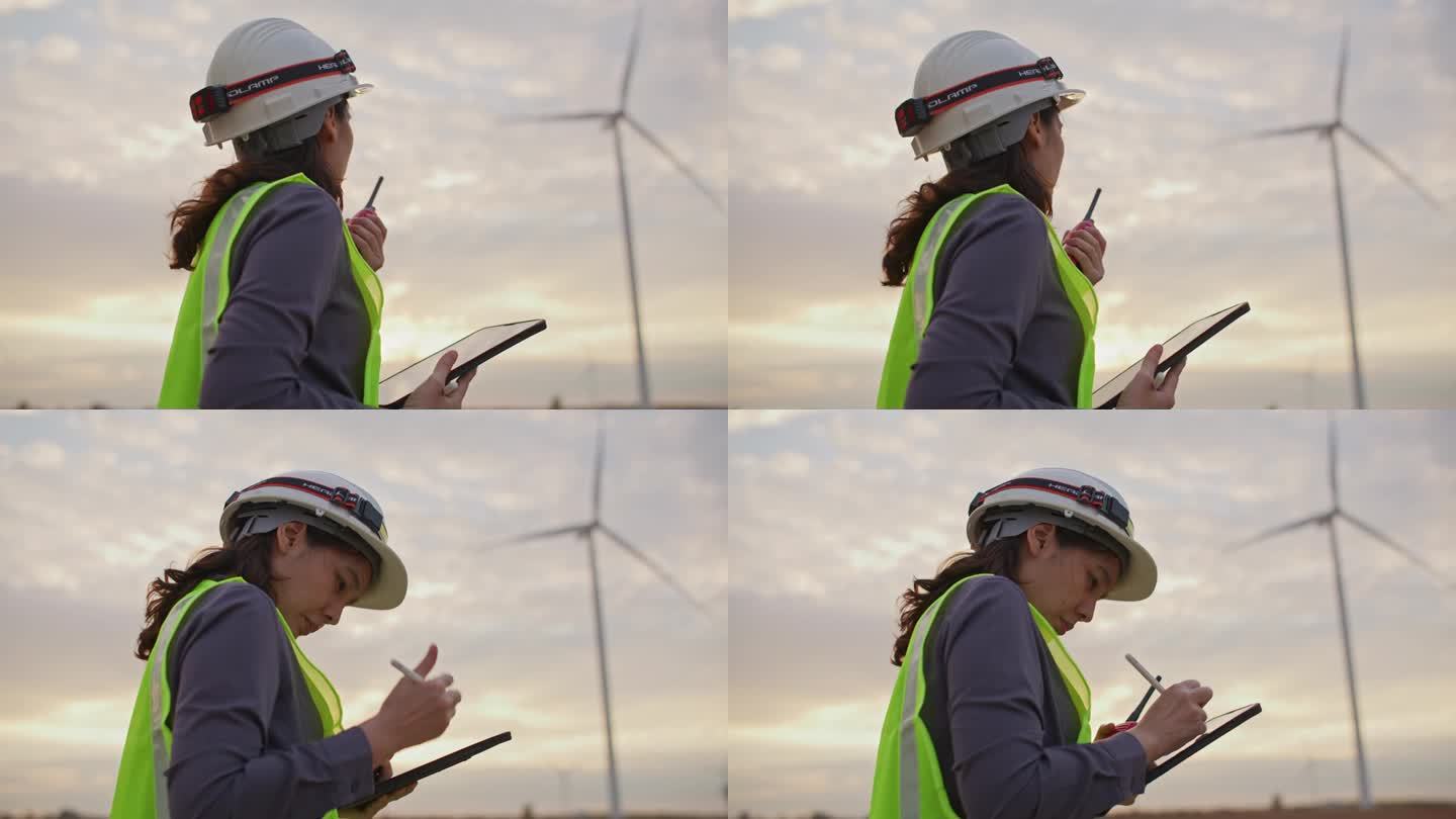 女工程师在风力涡轮机农场使用数码平板电脑