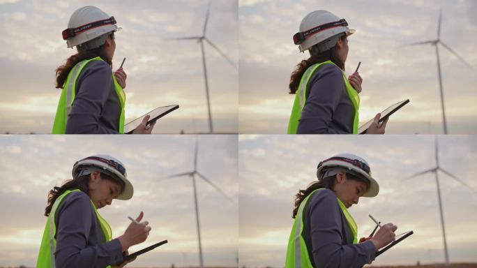 女工程师在风力涡轮机农场使用数码平板电脑